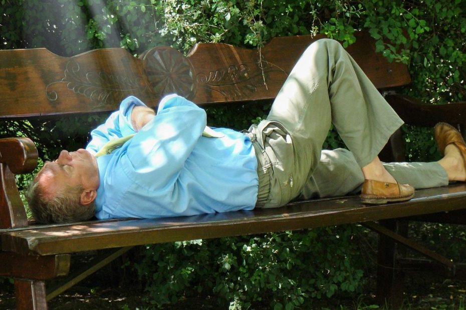 Homme allongé sur un banc, essayant de se retrouver, en souffrant en silence.