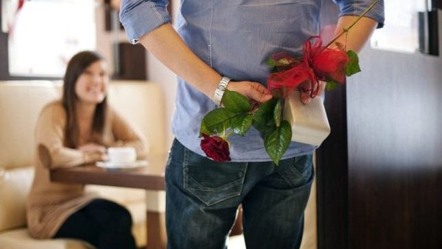 Homme, les mains dans le dos, tenant une fleur et un cadeau, pour laisser croire que tout sera parfait avec lui. Pour illustrer l'emprise émotionnelle et une relation toxique.